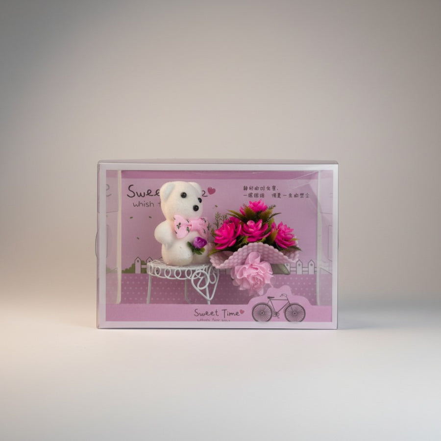 eRamis white teddy bear with pink bow holding a bouquet of pink flowers on a decorative cart