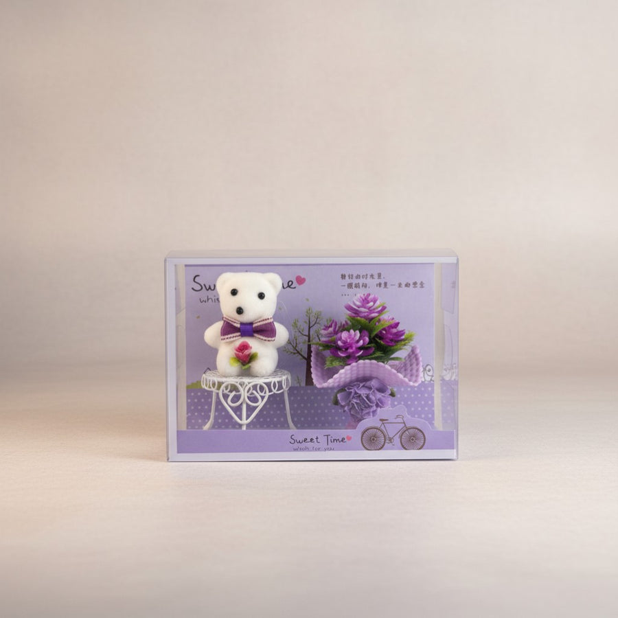 eRamis white teddy bear with purple bow and rose, with purple flowers and bicycle decoration.